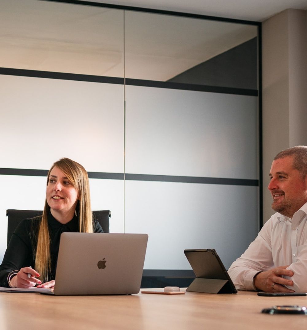 Marketing consultant managing automotive campaign details with a client.